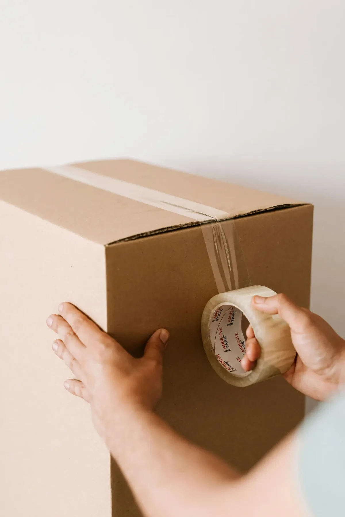 Packing tape being applied to a moving box